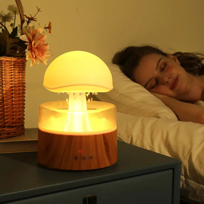 White cloud-shaped ultrasonic humidifier producing rainfall mist with colour-changing night light effects