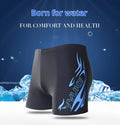 Men's plus size blue fire pattern boxer swimming trunks and matching swimming cap laid flat.
