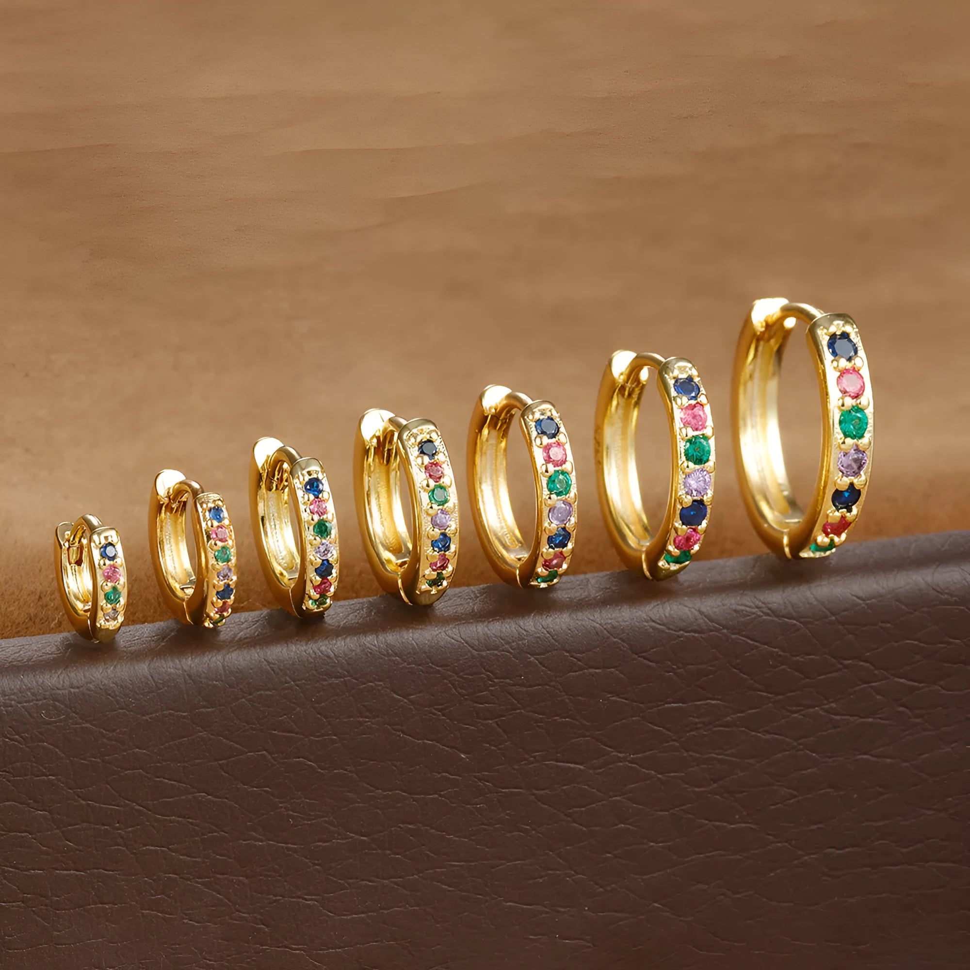 A pair of perforated circular stud earrings with zircon detailing in gold, rose gold, or silver colour.