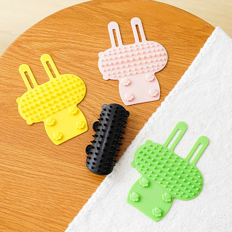 Silicone cat scratching comb with rounded teeth and adjustable strap in black, green, pink, or yellow colour.