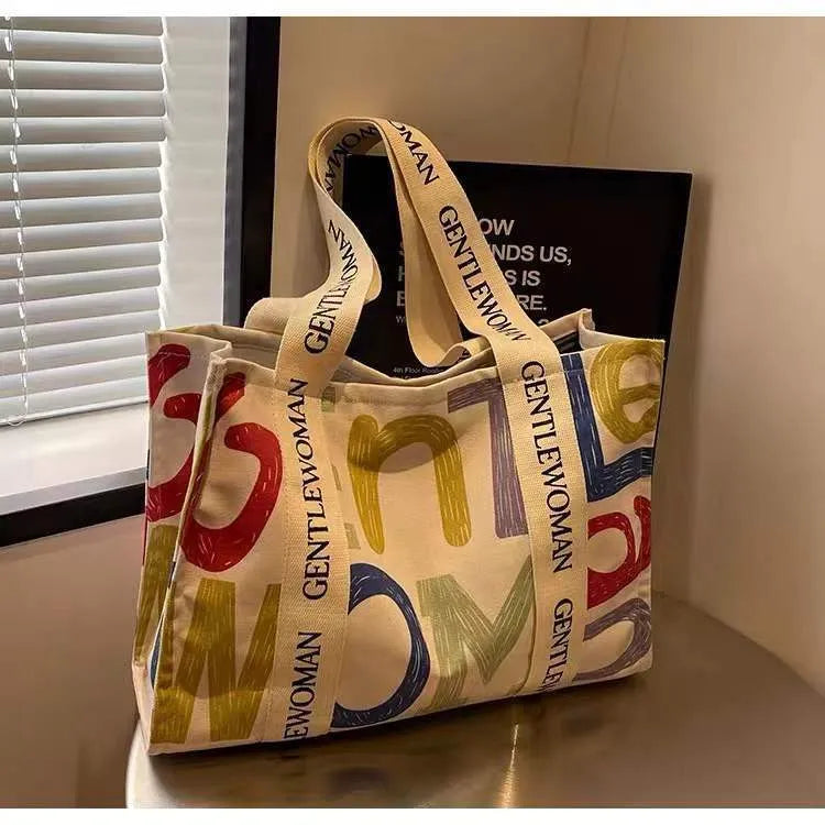 Canvas tote bag with printed design, available in black letters, coloured letters, and pattern style options.