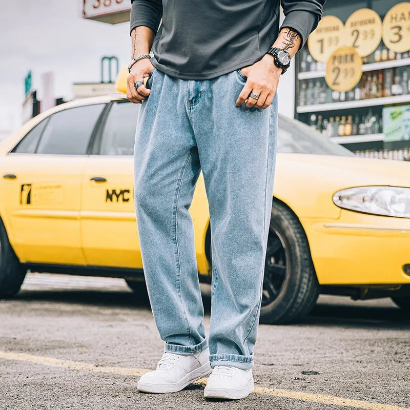Man wearing dark blue loose straight-leg casual jeans with a mid-waist and zipper fly.