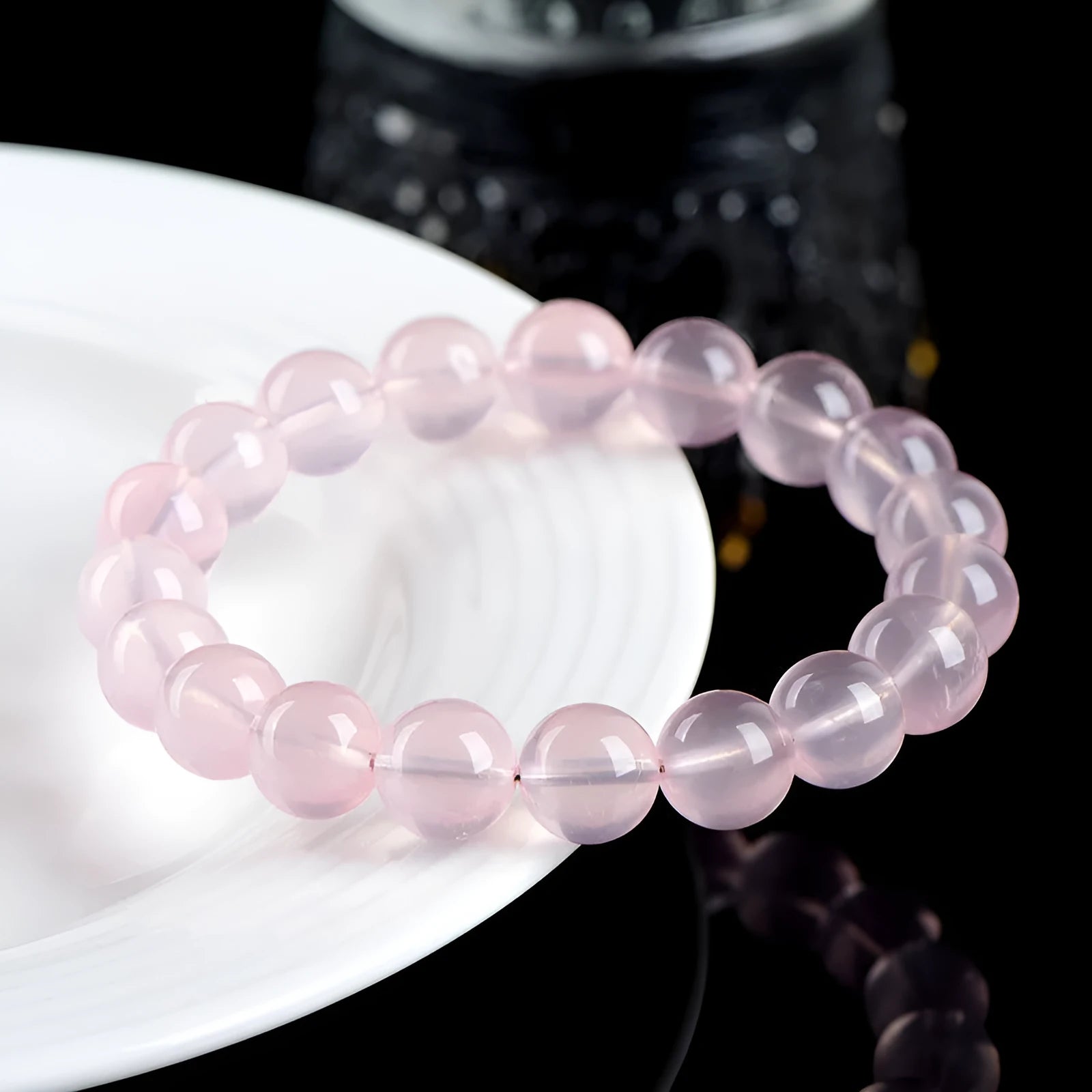 Women's pink polished crystal round bead bracelet in natural starlight style on a white background.