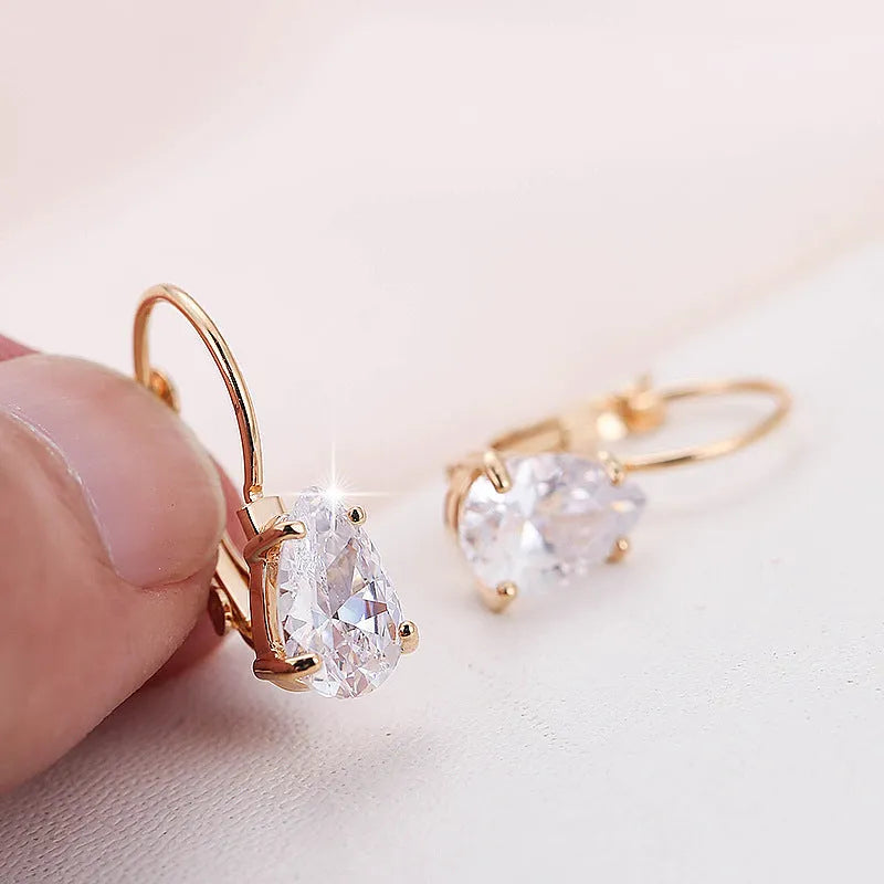 Women's drop-shaped metal earrings in gold or platinum colour with inlaid gem details