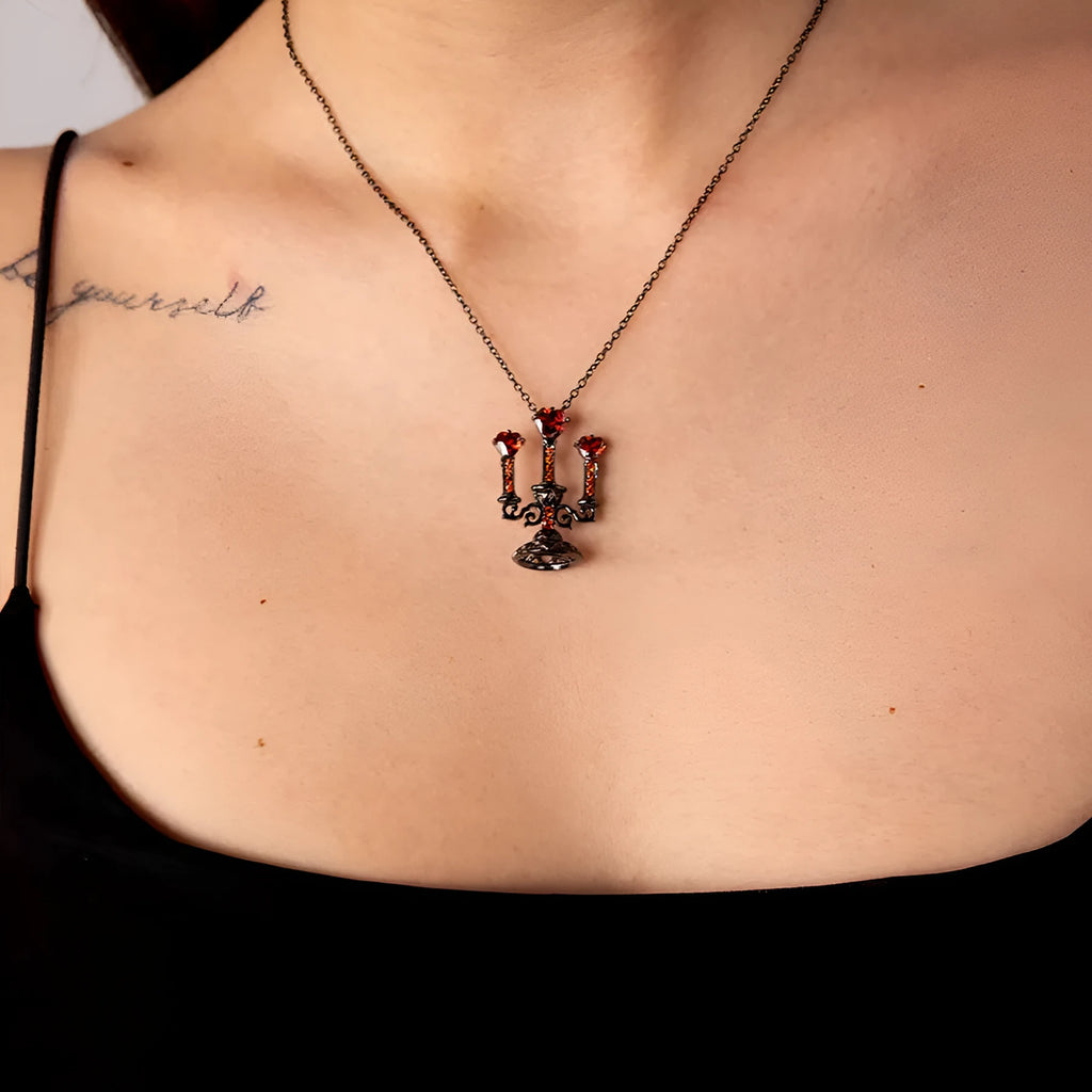 Close-up of a women's retro gothic necklace with a hollow candlestick pendant on a cross chain.