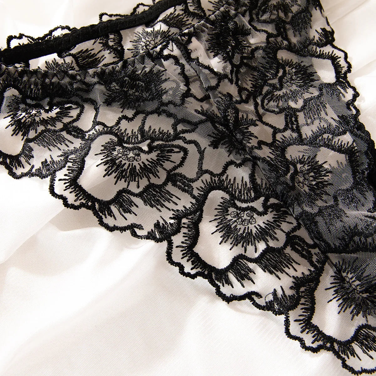 Women's black embroidered lace underwear set with steel ring details on transparent polyester fabric