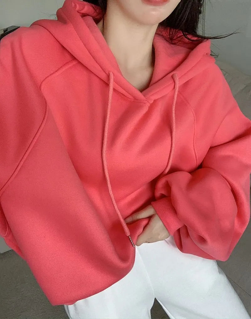 Watermelon red women's sleeveless silk hooded sweater on a hanger showing loose fit and hood detail.