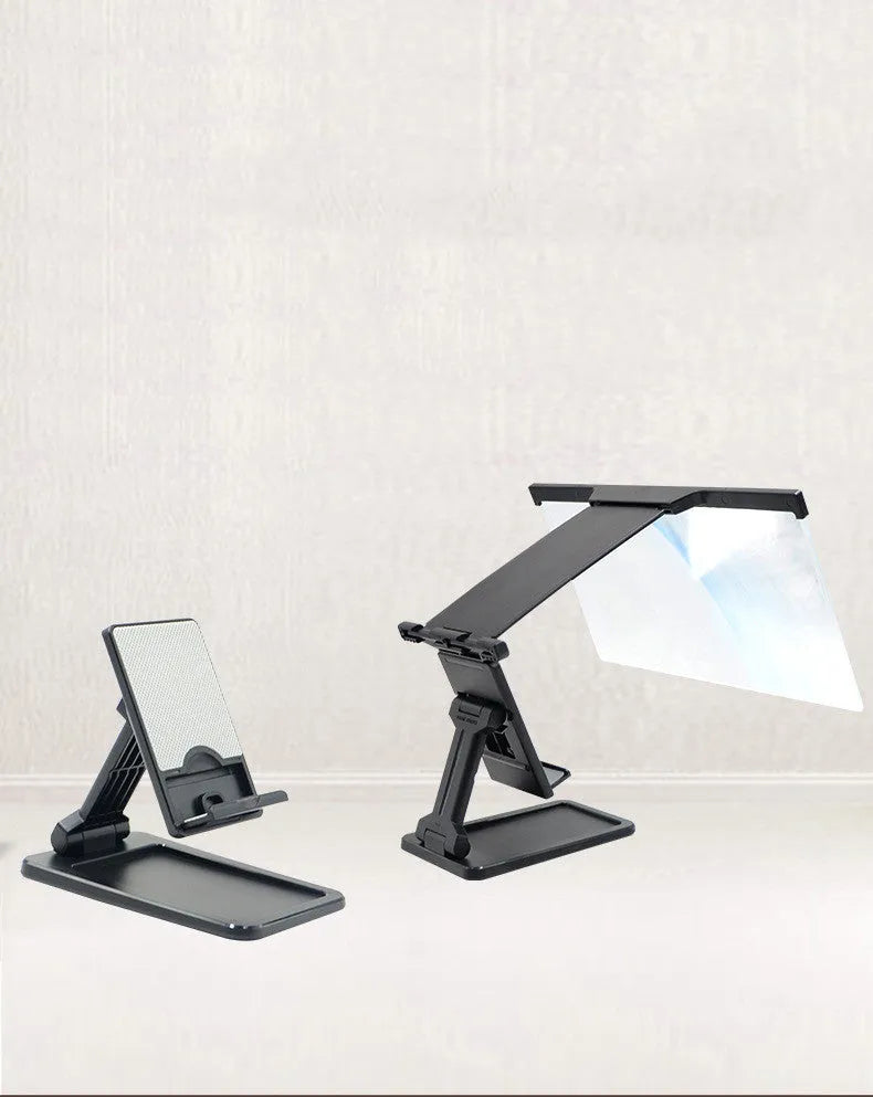 Black detachable mobile phone screen magnifier and holder set up on a desk, showing a phone displaying a magnified movie scene.