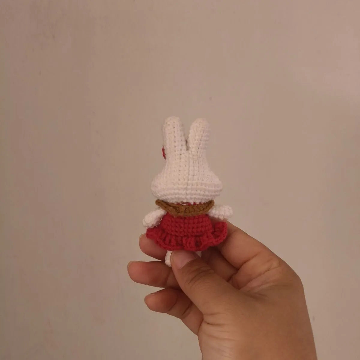 Hand-crocheted wool rabbit keychain pendant on a metal ring.