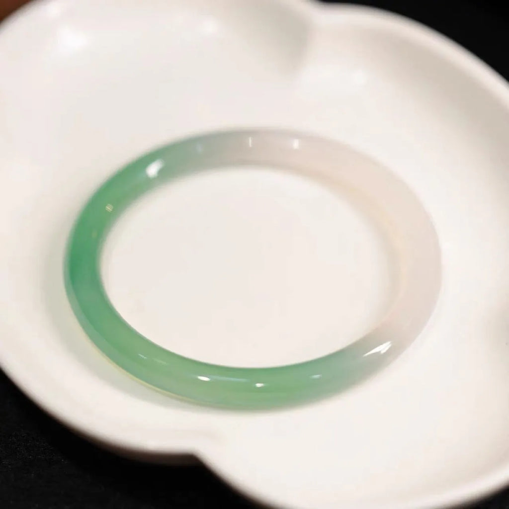 Chalcedony jade bracelet with carved southern mountain and water landscape motif.