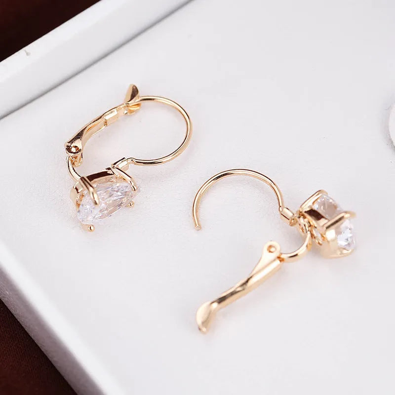 Women's drop-shaped metal earrings in gold or platinum colour with inlaid gem details
