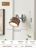 Small Scandinavian-style wall lamp with walnut wood finish, mounted on a wall.