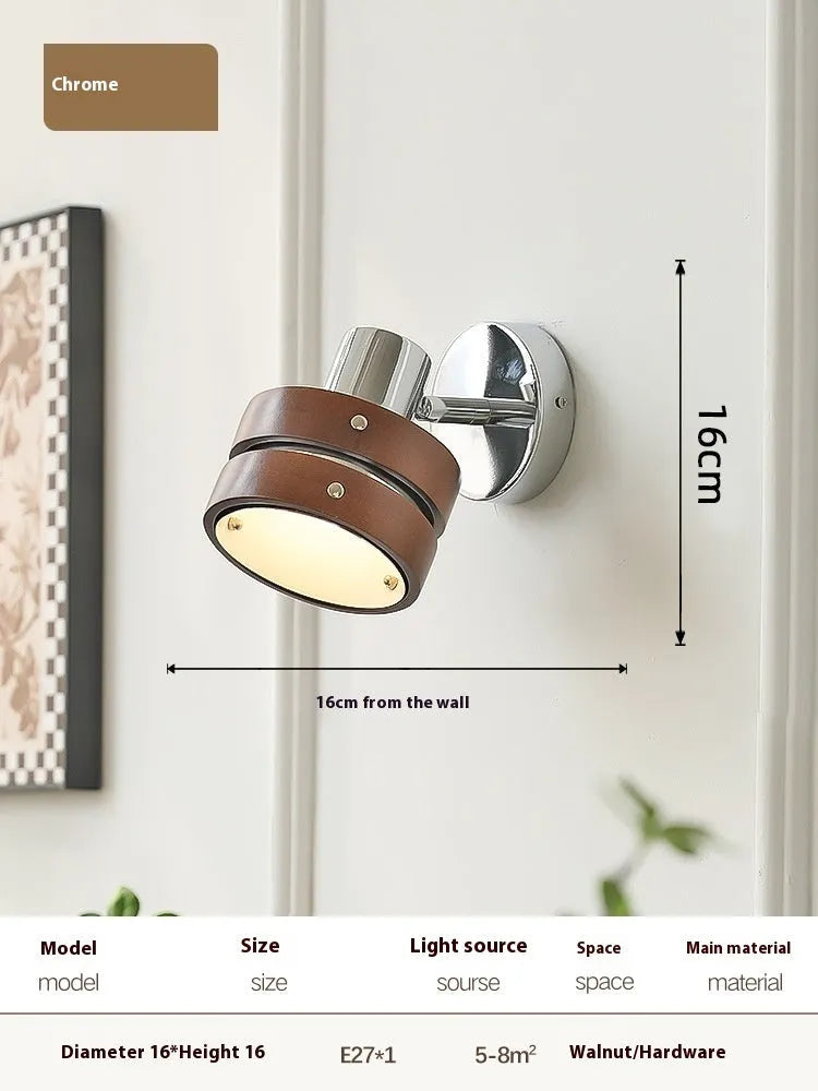 Small Scandinavian-style wall lamp with walnut wood finish, mounted on a wall.