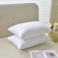 White cotton satin stripe feather pillow showing simple design and hotel-style aesthetic