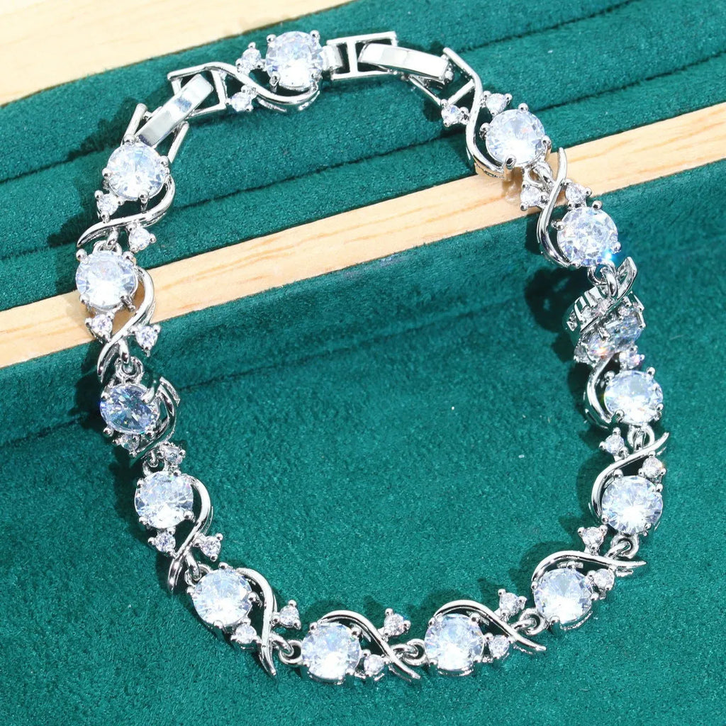 Bridal zircon and alloy four-piece jewellery set showing necklace, earrings, bracelet, and ring in white colour