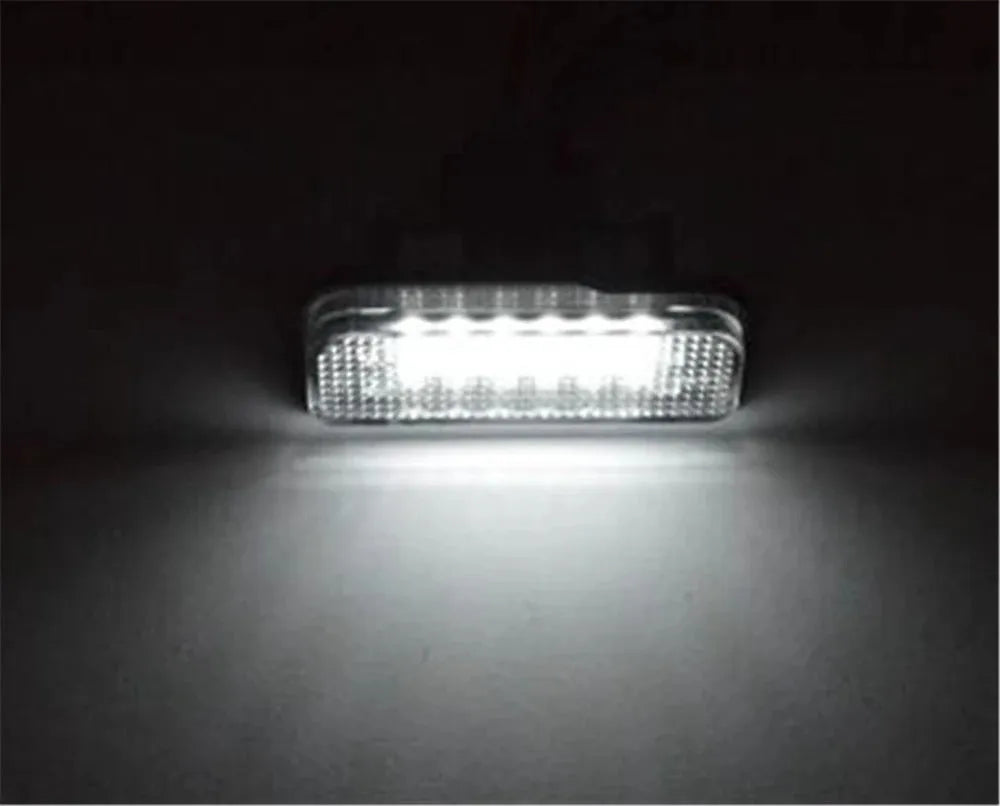 Mercedes Benz LED licence plate light unit with 18 white LEDs, shown next to a ruler for scale.
