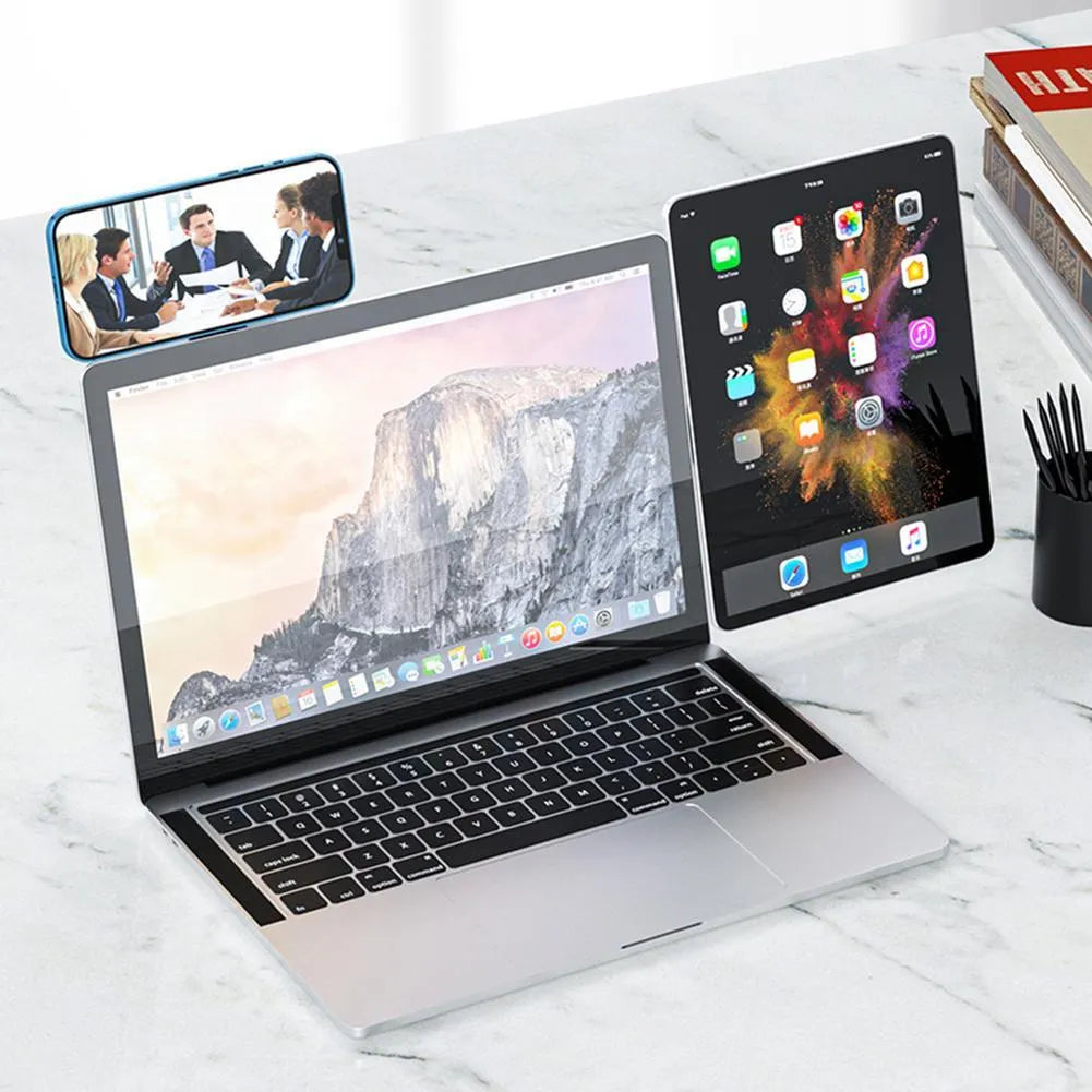 Black aluminium laptop phone holder with magnetic clip attached to a monitor, holding a smartphone