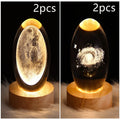 LED galaxy crystal ball night light with 3D planet designs on a table
