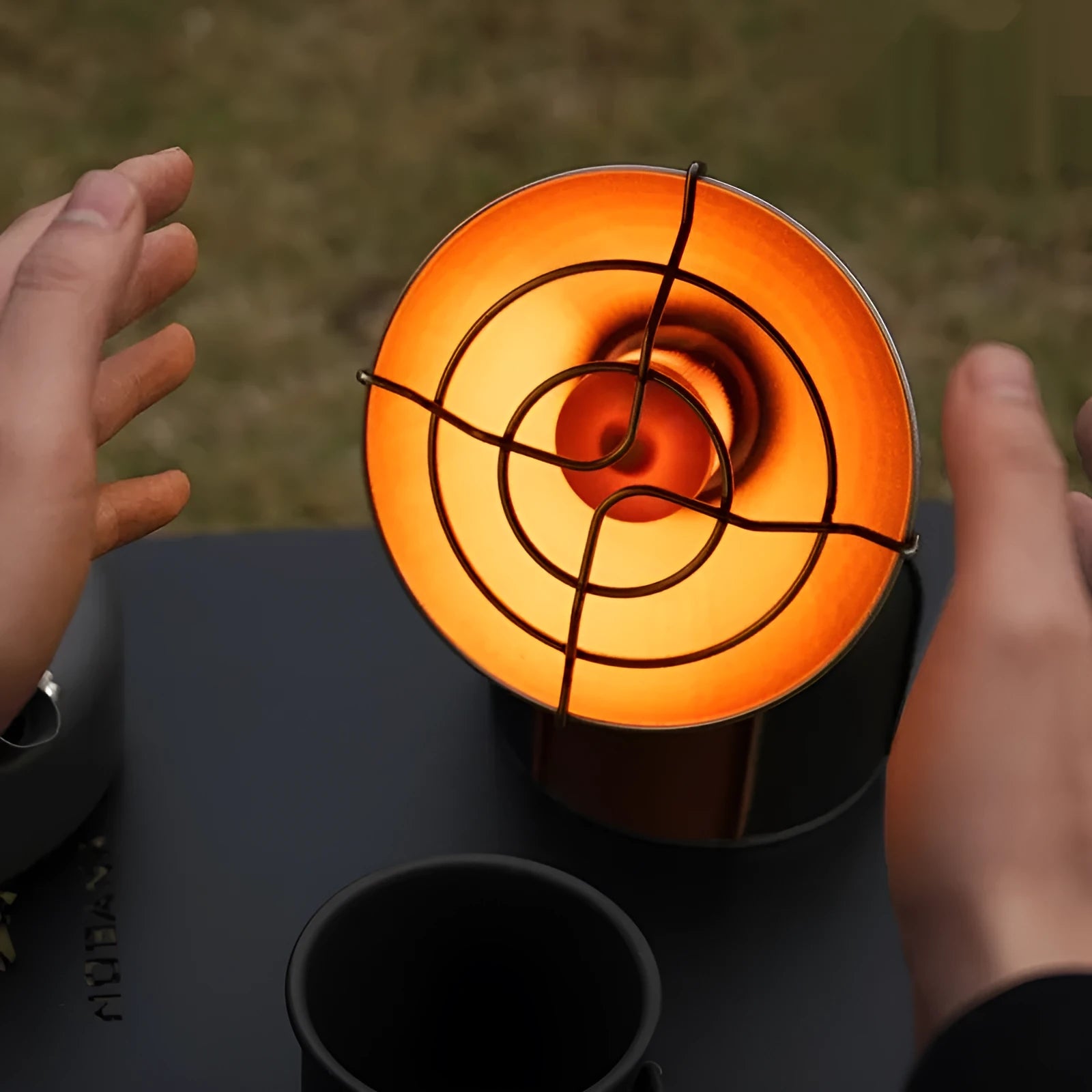 Black and orange portable outdoor heater stove with automatic ignition for camping.