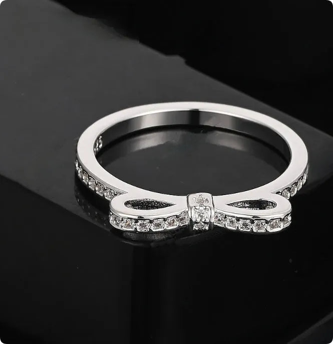 Silver bow-shaped ring with zircon rhinestone crystals on electroplated band