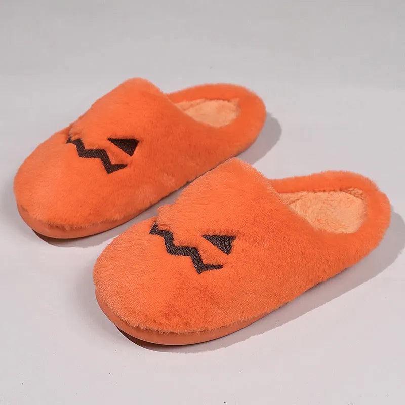 Orange Halloween pumpkin-themed plush slippers with a coral velvet upper and flat heel.