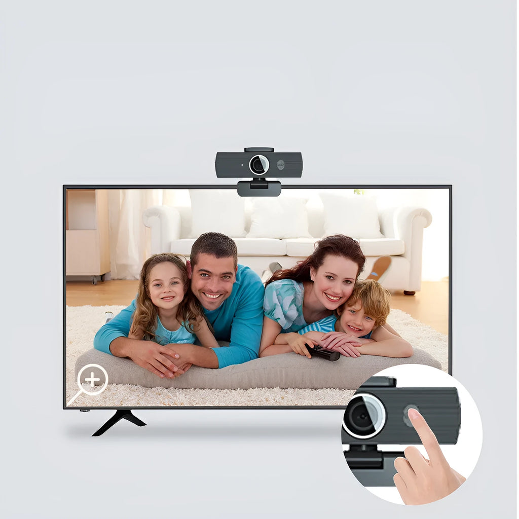 Black USB webcam with magnetic privacy cover on a desktop next to a laptop.