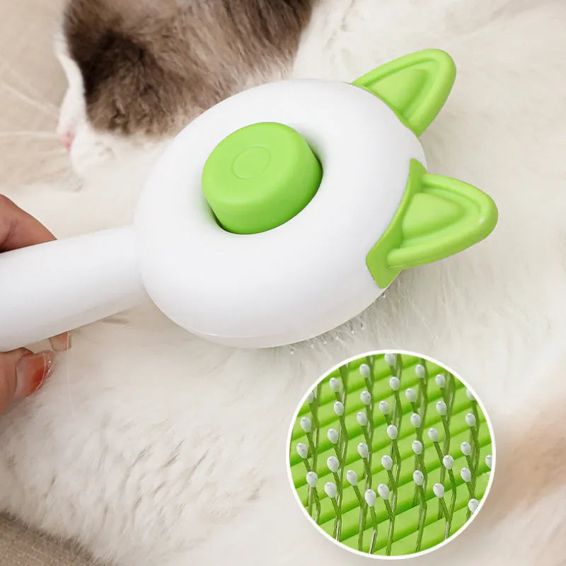 Greenish white cat grooming brush with stainless steel teeth and a self-cleaning button on the handle.