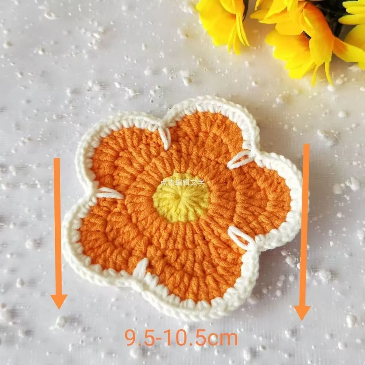 Set of five handmade woven flower placemats in blue, green, orange, pink, and purple colours on a wooden table.