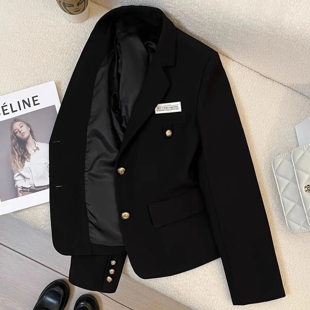 Women's black loose fit polyester short suit coat with long sleeves and pocket detailing