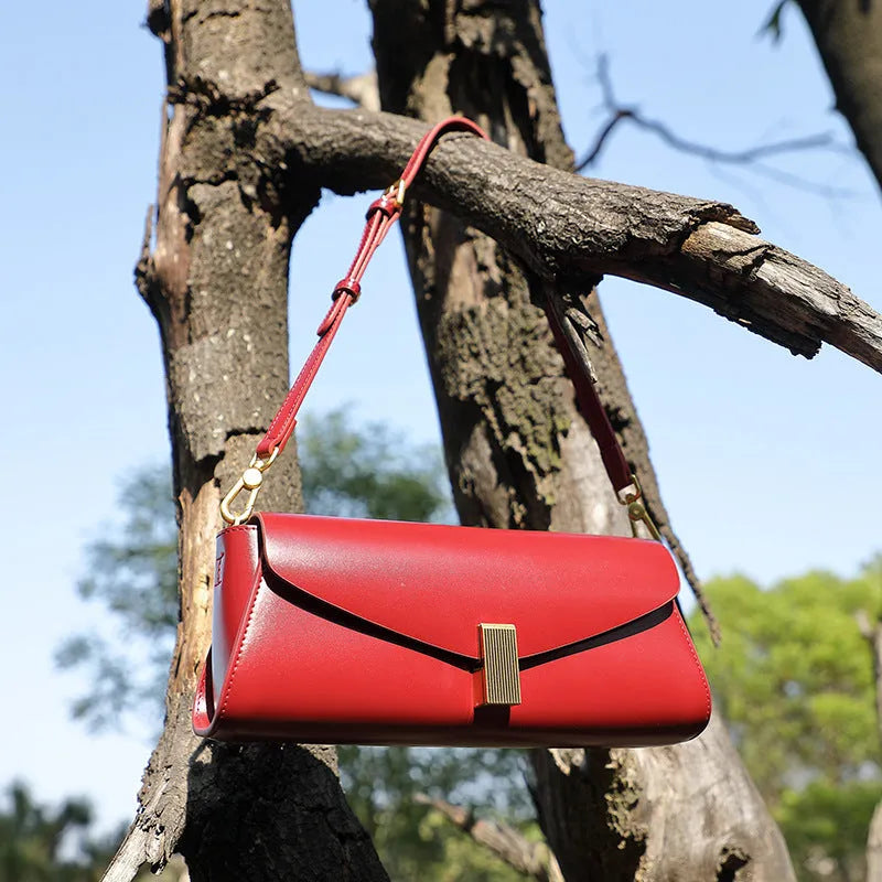 Cowhide leather women's cross-body bag in a clamshell, pillow-shaped design.