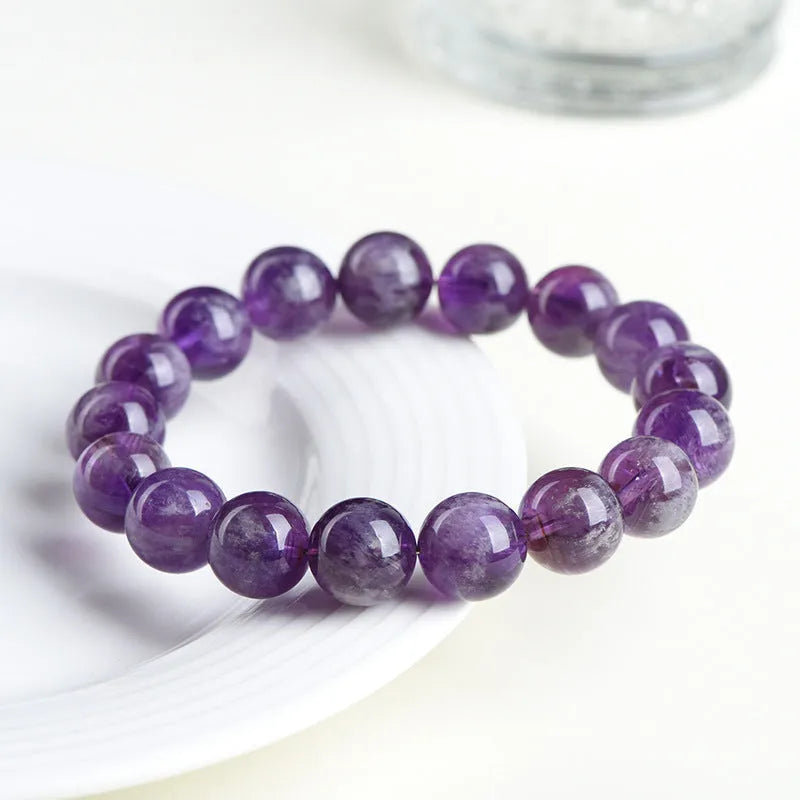 Natural purple feather amethyst crystal bracelet with geometric design and Ruyi element on wrist.