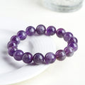 Natural purple feather amethyst crystal bracelet with geometric design and Ruyi element on wrist.