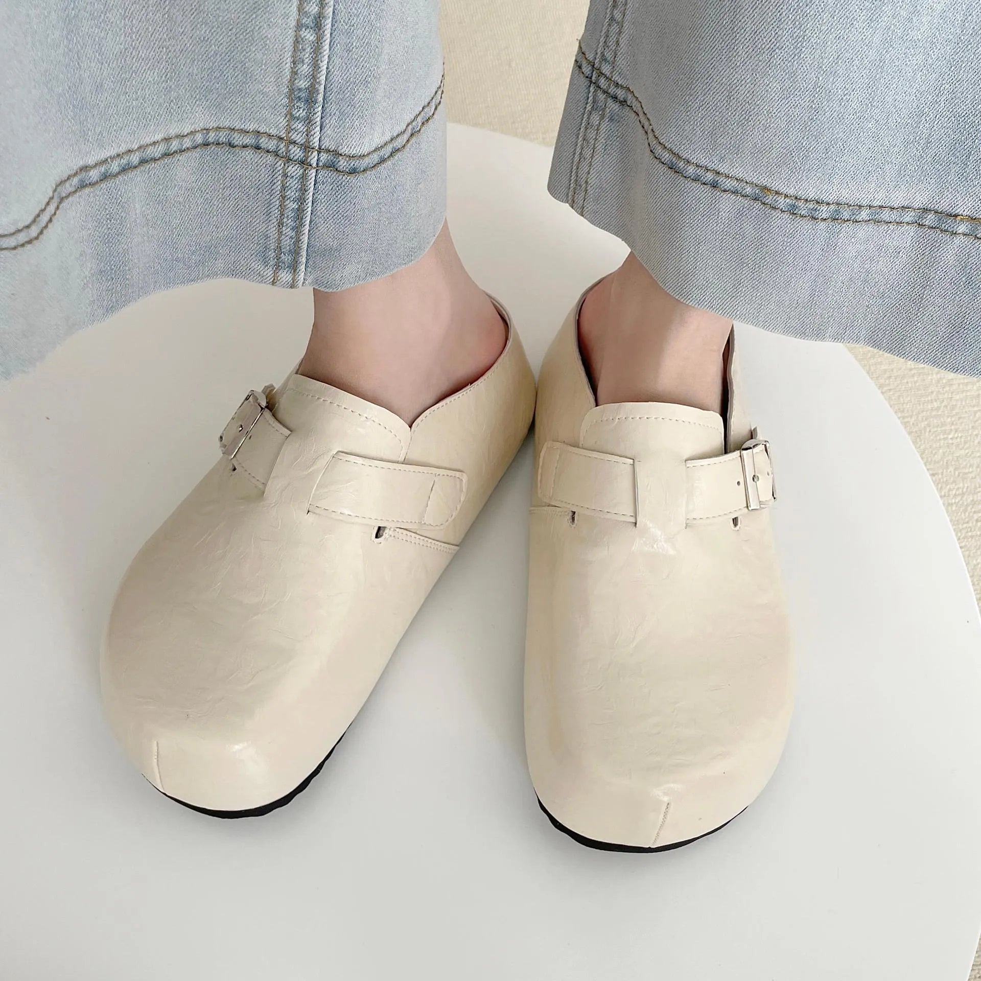 Flat round-toe casual sneakers with a metal buckle on the PU upper.
