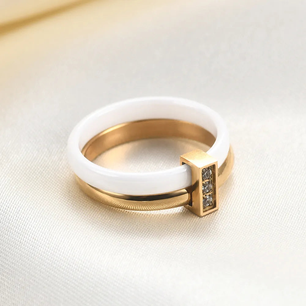 Glossy black ceramic women's ring with geometric shape and inlaid zirconium details on a finger.