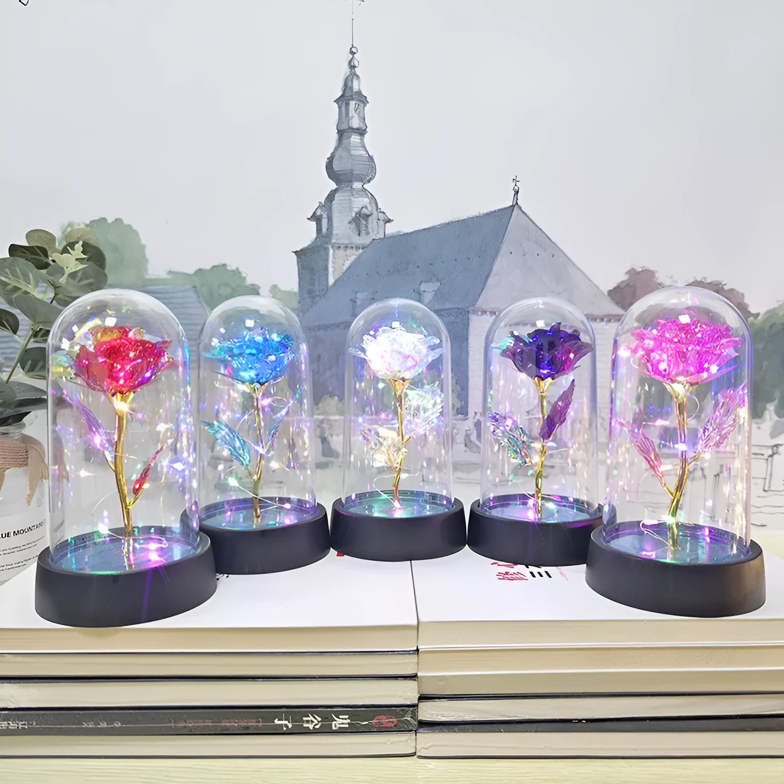 Small glass dome night lamp with colourful plastic flowers inside on a black base.