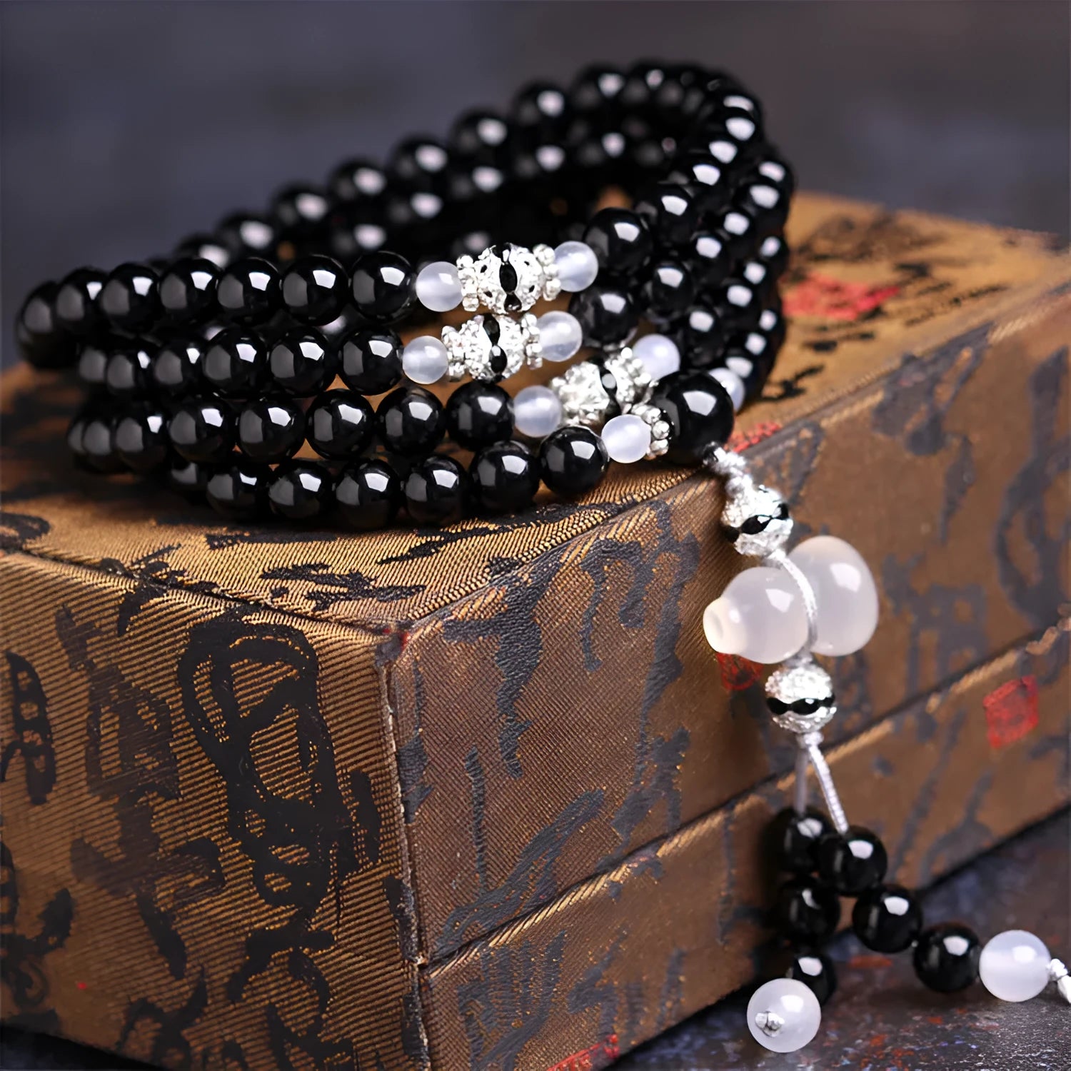 Black agate bracelet with 108 geometric beads and number details on a wrist.