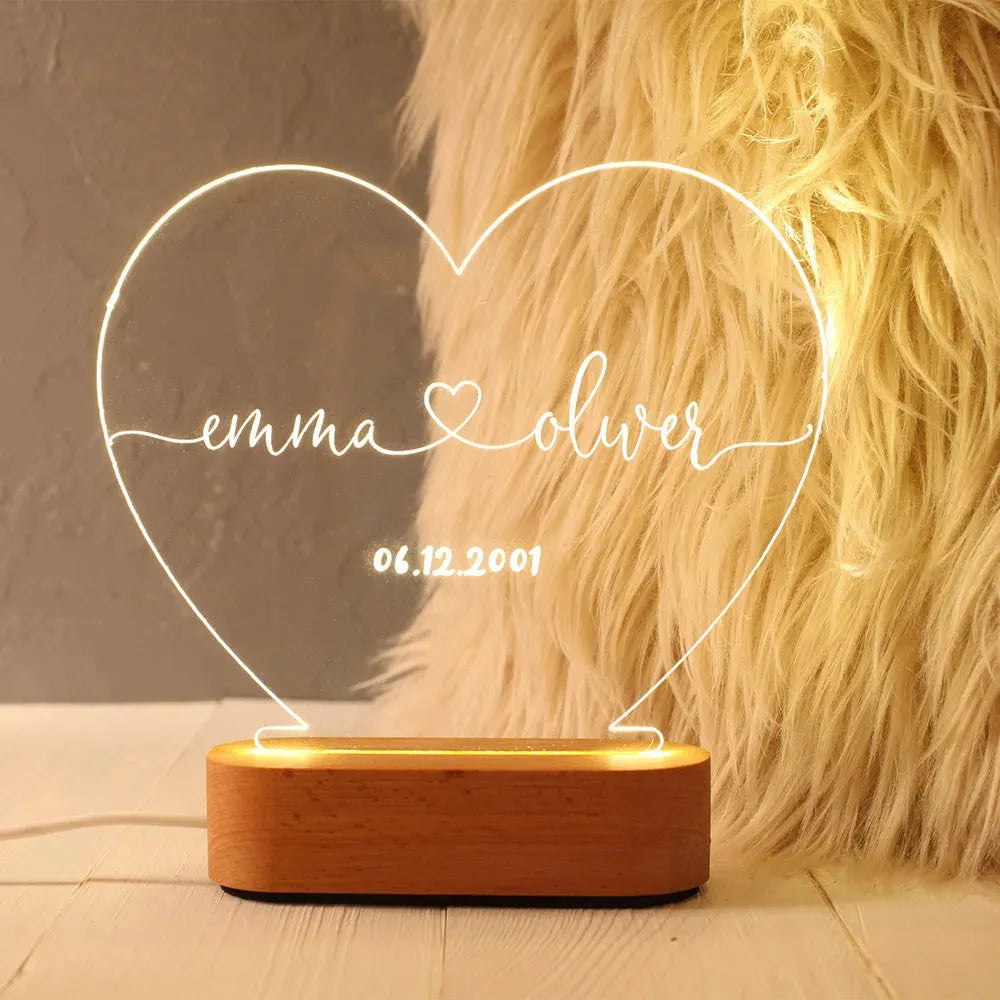 Custom transparent acrylic night light with personalised text, lit by LED, on a bedside table.