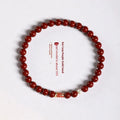 Hand-woven purple gold sand and strawberry quartz koi bracelet with crystal and pearl beads on a light background.