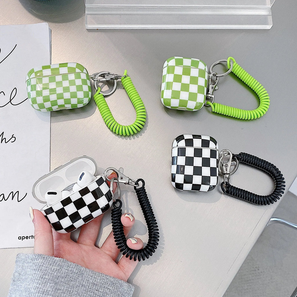 Black and green checkerboard patterned TPU protective case for Apple AirPods with optional lanyard and loop pendant attachments.