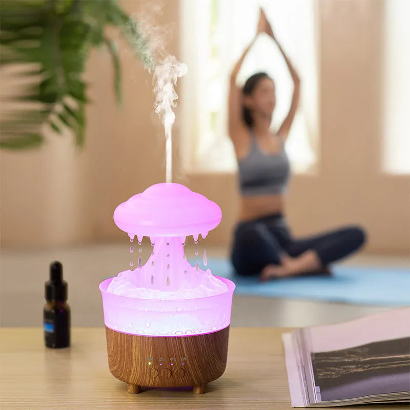 Wood grain white rain cloud-shaped ultrasonic humidifier diffuser with LED lights on a table.