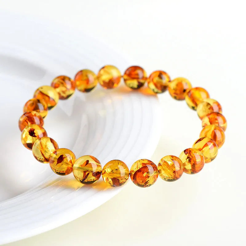 Natural yellow piebald amber geometric bracelet on a white background.