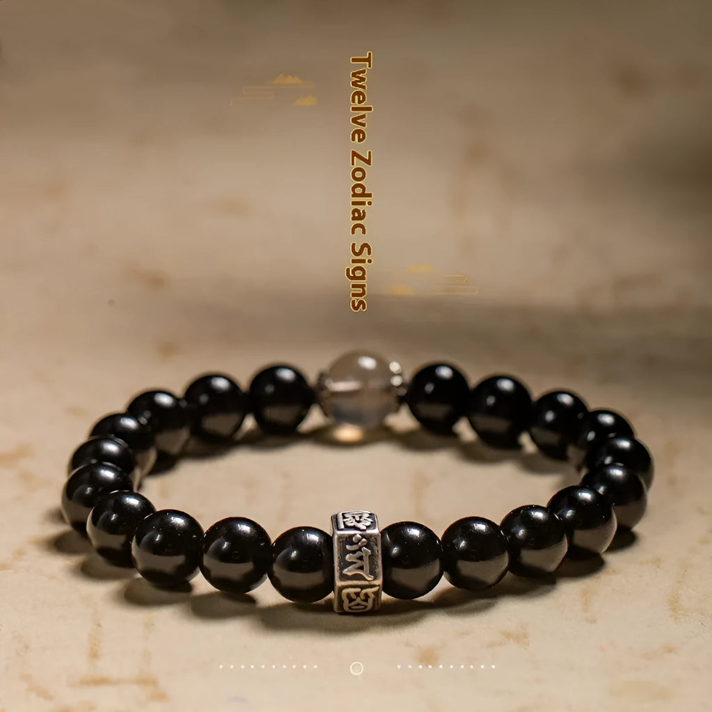 Black obsidian bracelet with 8mm beads carved with Zodiac animal and Buddhist bodhisattva designs.