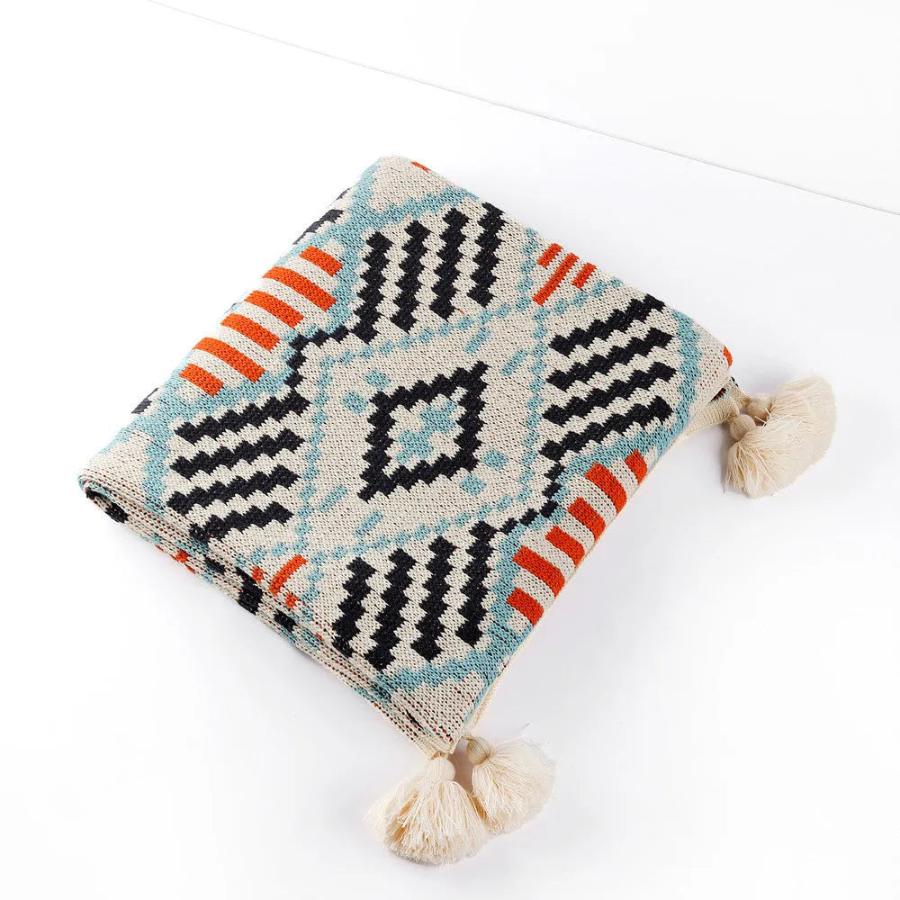 Bohemian style acrylic sofa cover blanket with tassel trim in a geometric pattern colour option.