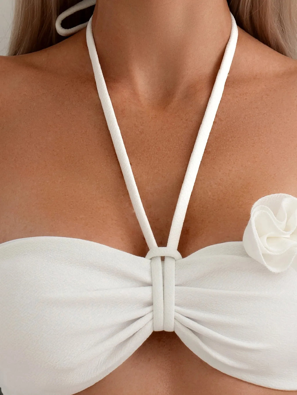 White halter bikini with three-dimensional flower pattern and lace-up detailing