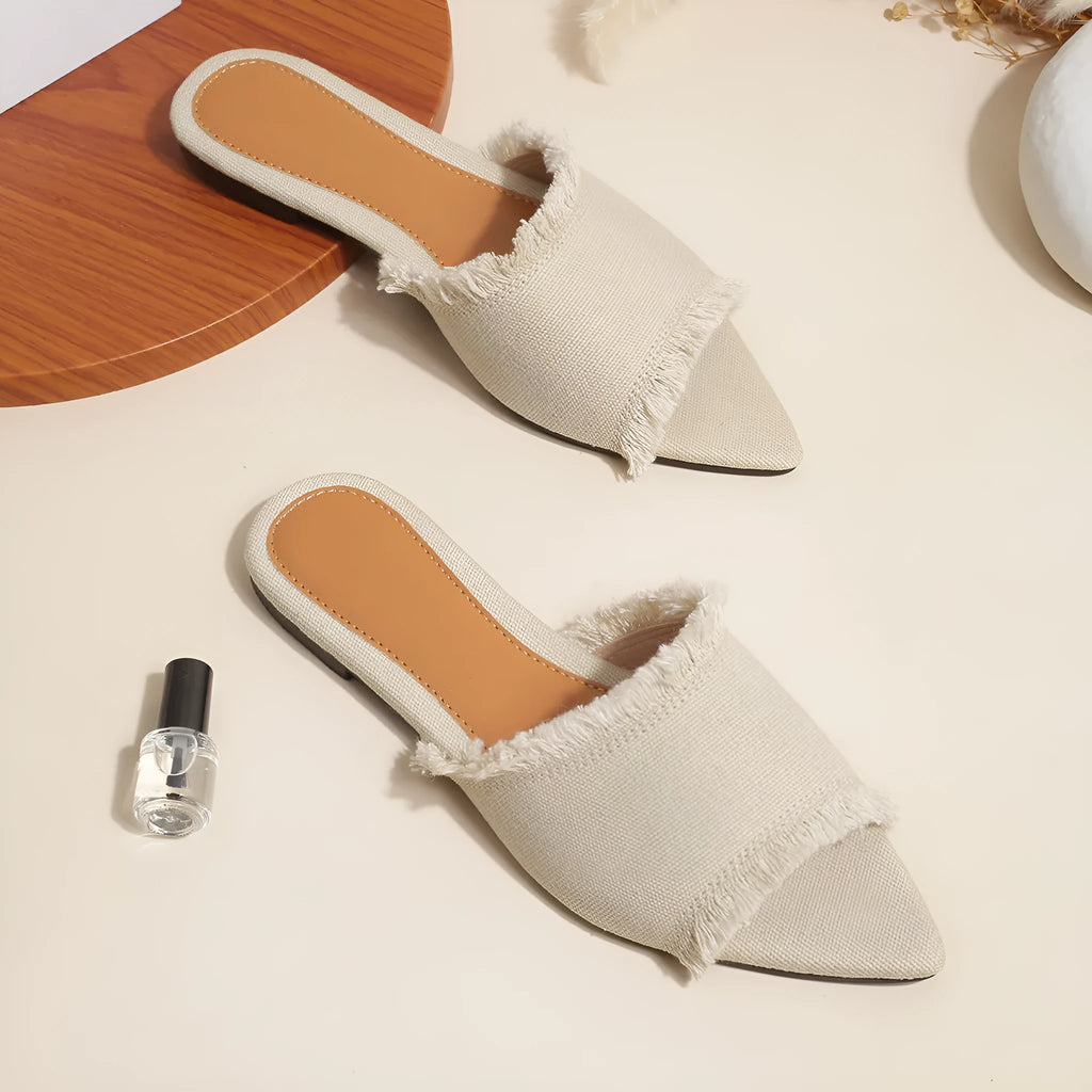 Women's apricot denim flat slippers with a tassel detail and leather lining.