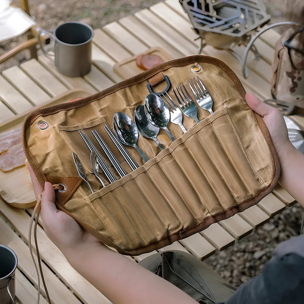 Beige waxed canvas tableware storage bag with wooden handle chopsticks, knives, forks, and spoons inside.