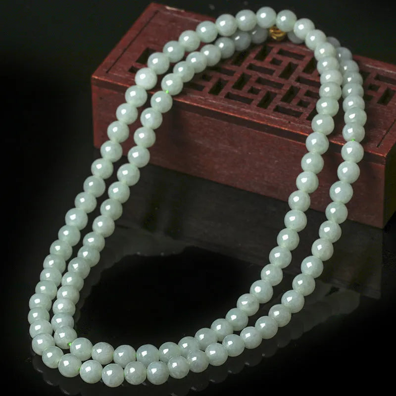 Adjustable necklace with a round white and green jade bead on a silver chain.