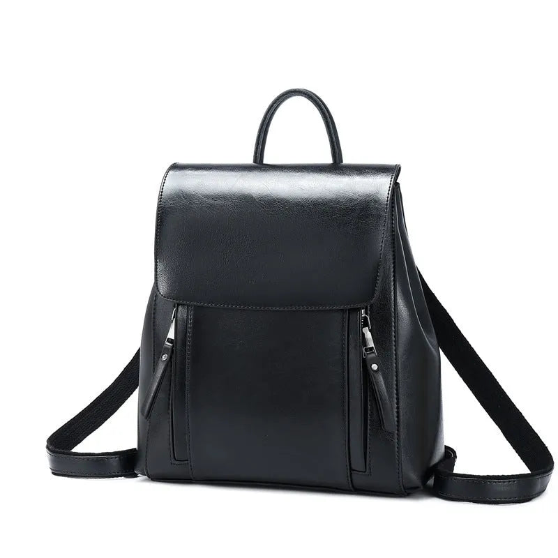 Large genuine cowhide leather women's backpack in black, shown with open cover to reveal internal zipper pockets and phone sleeve.