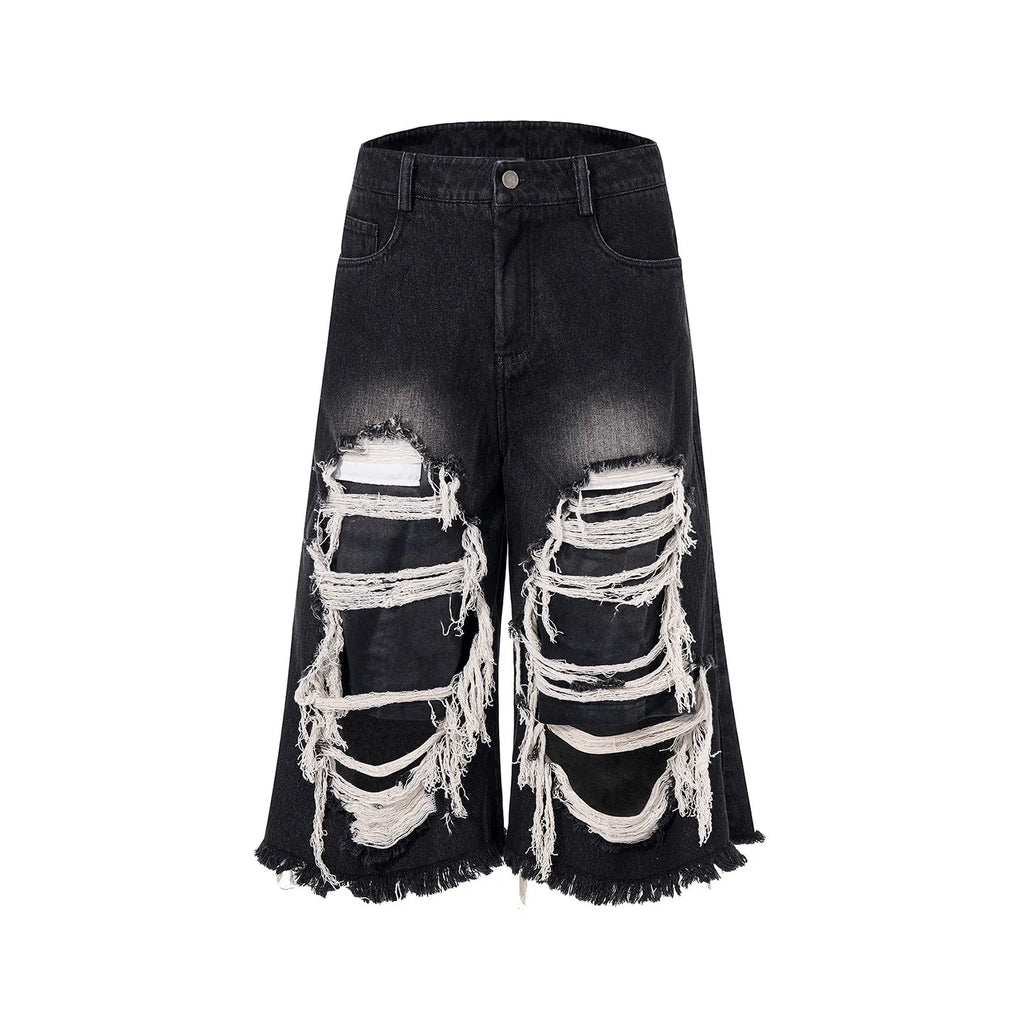 Model wearing black cropped wide-leg jeans with a distressed patch detail on the leg.
