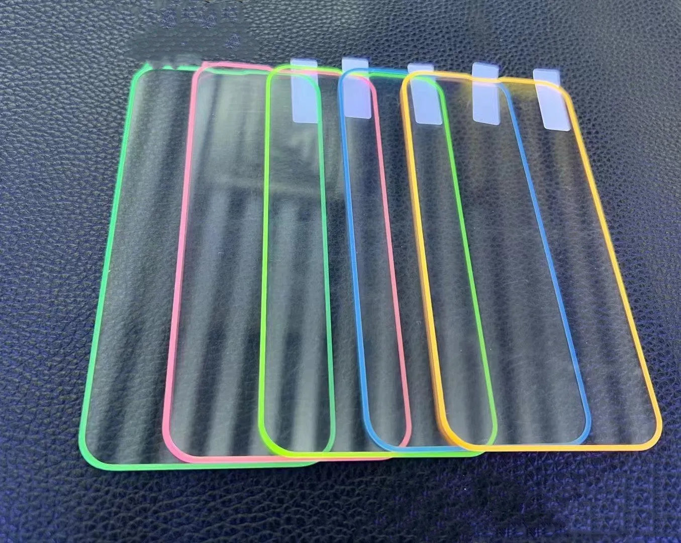Fluorescent pink tempered glass screen protector glowing on an iPhone 13 Pro Max.